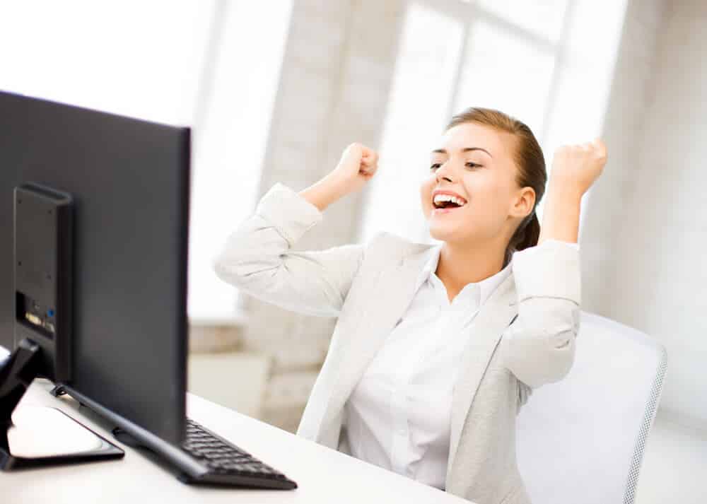 woman celebrating at her computer